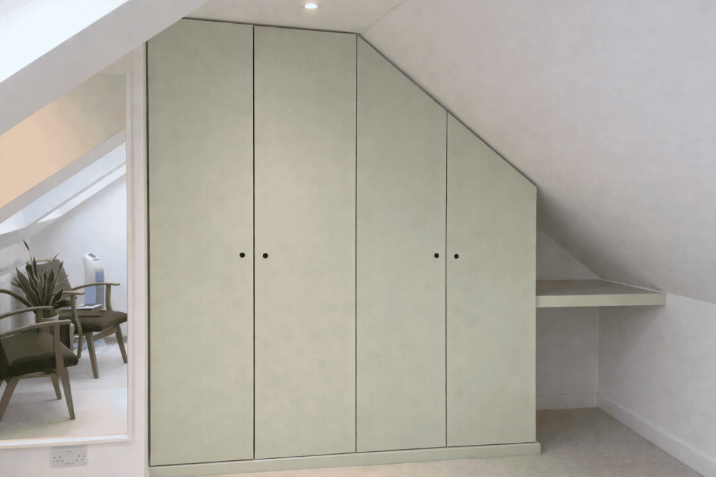 Simple fitted wardrobes in attic conversion with sloping ceiling